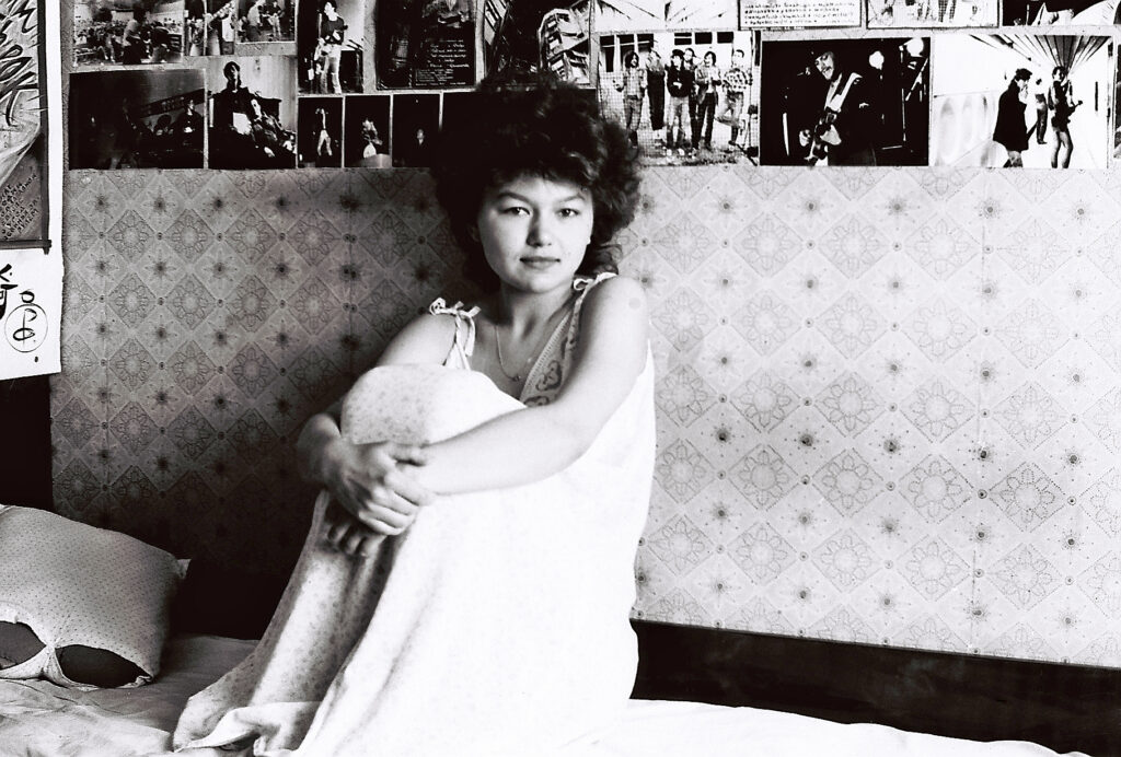 Инна Диконбаева на фоне плакатов и фотографий «Рок-Фронт» и «Группа Продлённого Дня». Харьков. Лето 1989 года. Фото из семейного архива Чернецких.